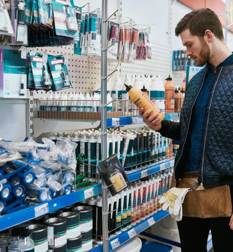 Man-holding-a-home-improvement-product-in-an-aisle